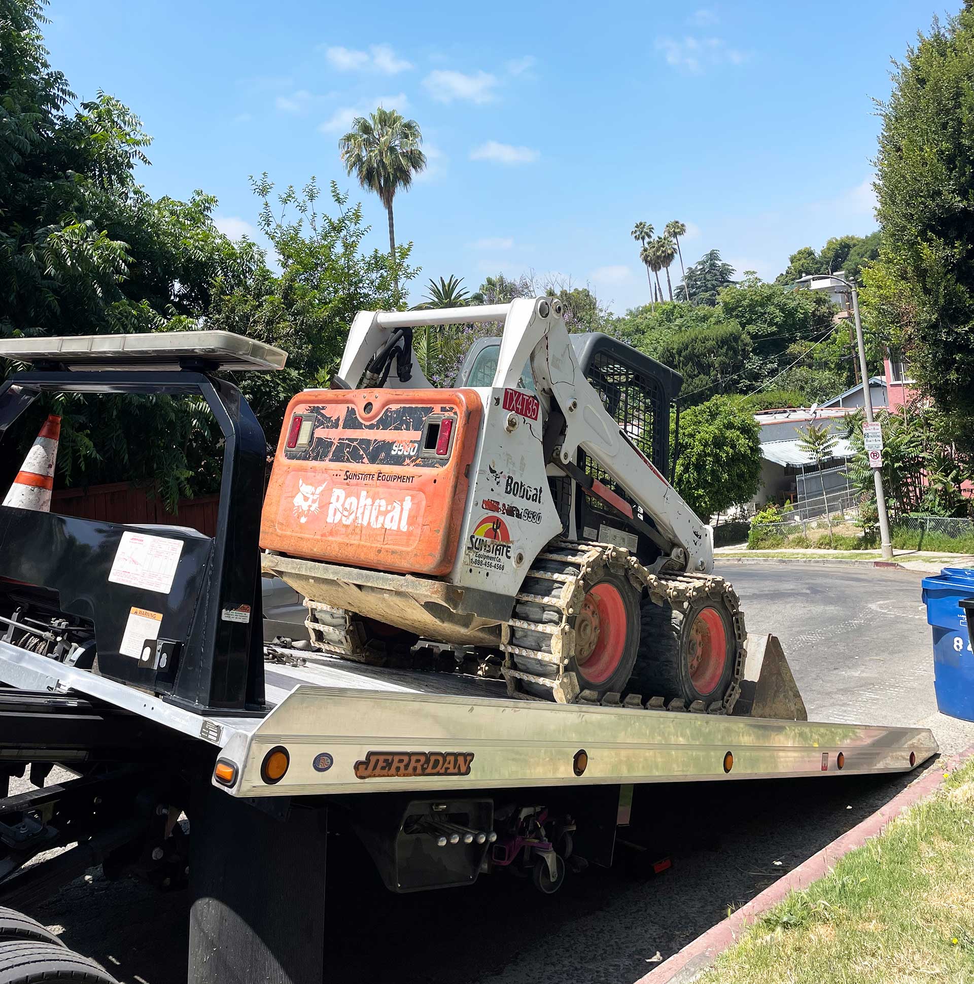 Bobcat tractor being transported by flatbed